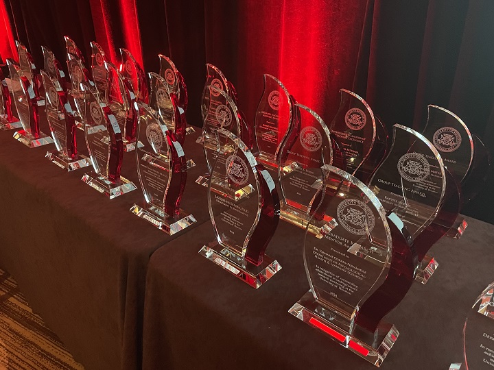 Faculty Excellence Award trophies lined up on tables